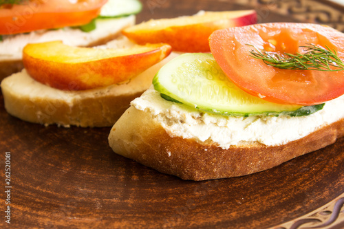 Vegetarian sandwiches with cream cheese, cucumbers and tomatoes, healthy snack.