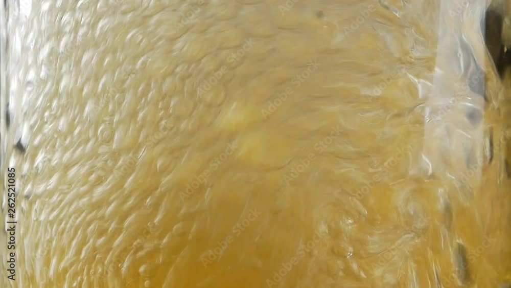 Close up of air bubbles created by someone blowing with straw into full glass of beer or soda Close up of air bubbles created by someone blowing with straw into full glass of beer or soda