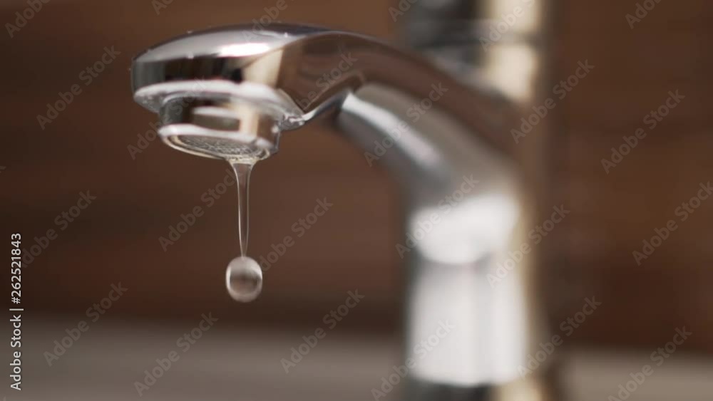 Panoramic shot of dripping tap in bathroom. Water waste, slow motion Panoramic shot of dripping tap in bathroom. Water waste, slow motion