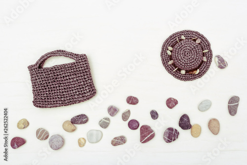 Sun hat, beach bag and sea stones. Outfit for beach holiday. Summer flat lay. Copy space. Top view.