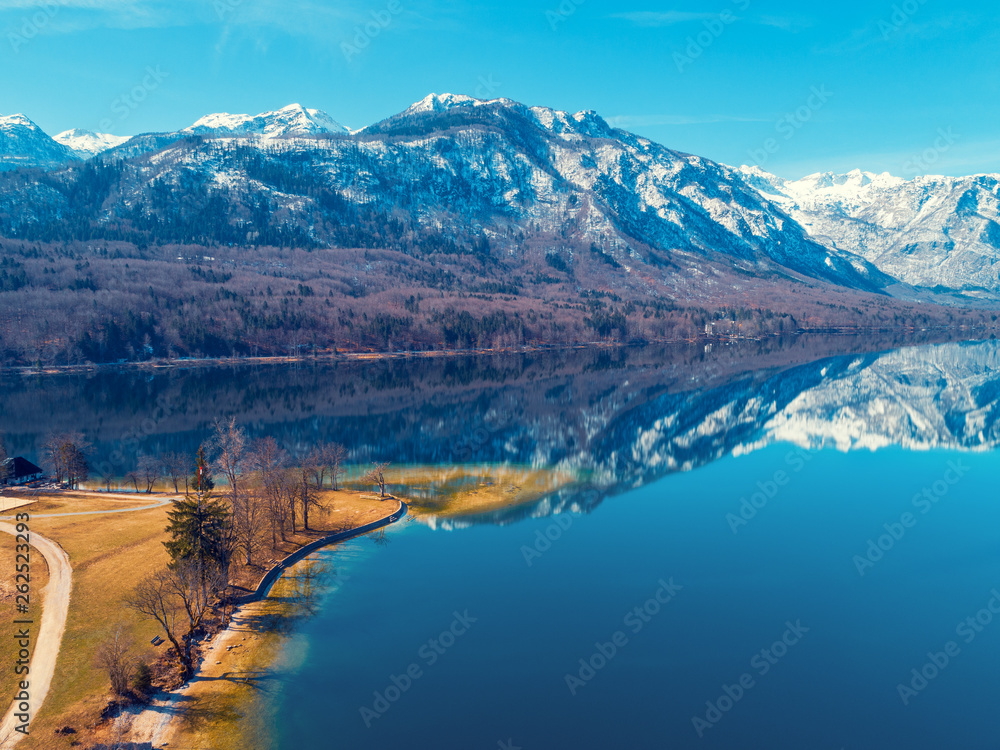Mountain lake in early spring with snowy peaks. Beautiful nature. Reflection on the lake