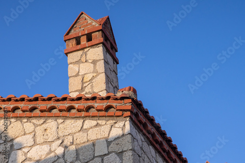 Canvas Print Rroof under constructions with lots of tile and red brick chimney in summer