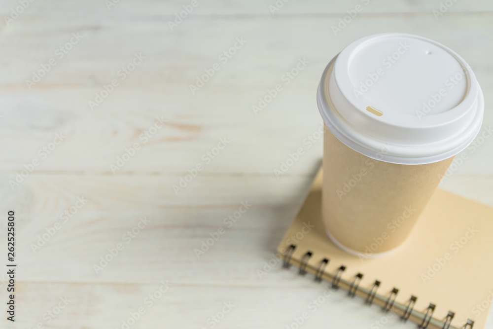 craft paper coffee cup and notebook diary with copy space on wooden background craft paper coffee cup and notebook diary with copy space on wooden background