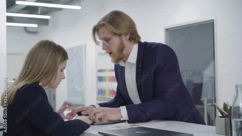 Young bearded man trying to cheer up female colleague, who involved in ...