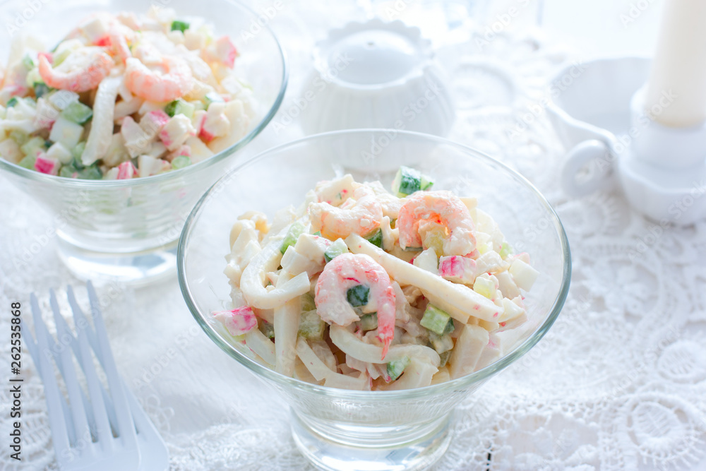 Salad with seafood: squid, shrimp, crab sticks in glass salad bowls, horizontal Salad with seafood: squid, shrimp, crab sticks in glass salad bowls, horizontal