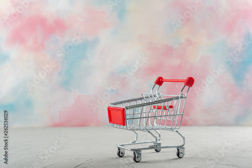 Supermarket trolley on a colored background