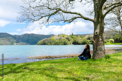Fototapeta Naklejka Na Ścianę i Meble -  Girl looking over Sete Cidades lake into the mountains, Azores, Portugal.