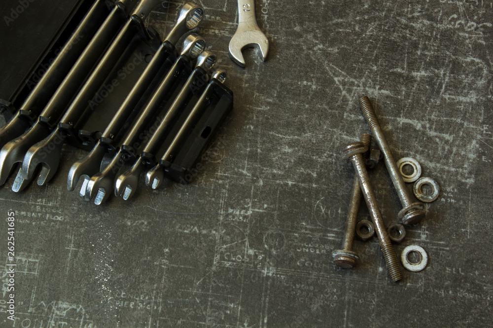 Tool set of wrenches, bolts and nuts on abstract grey surface Tool set of wrenches, bolts and nuts on abstract grey surface