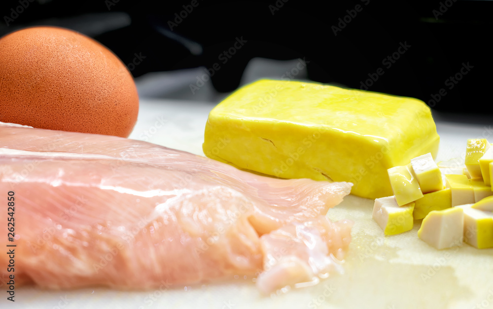 Raw ingredient of Egg, Tofu and Chicken Breast on a Cutting Board . Raw ingredient of Egg, Tofu and Chicken Breast on a Cutting Board .