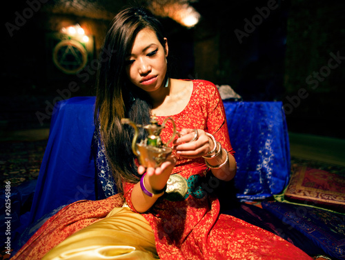 young pretty asian girl in bright colored interior on carpet photo