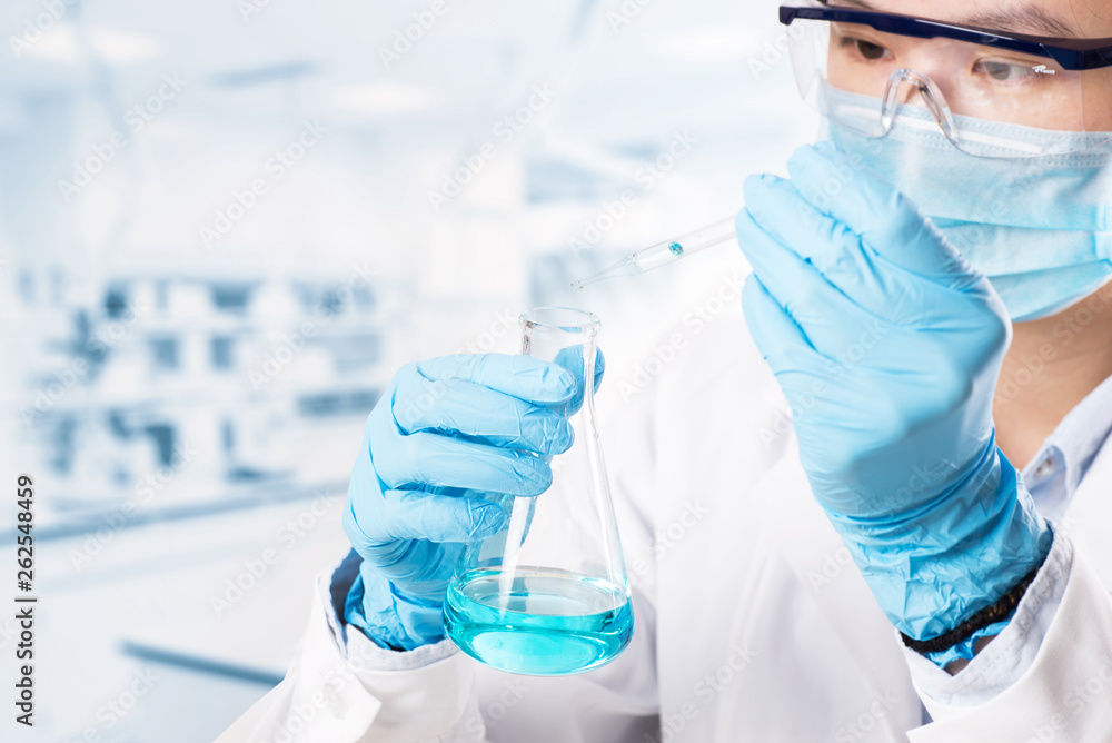 Fototapeta premium Laboratory beaker in analyst's hand in plastic glove
