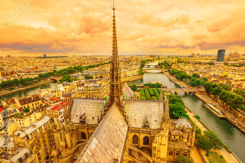 Panoramic aerial view of the spire of Notre Dame cathedral with statues, in Paris city capital of France. From top of the gothic church Our Lady of Paris, aerial on Paris sunset skyline.