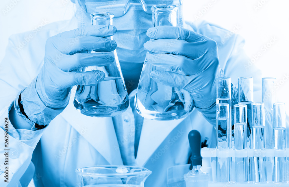 Fototapeta premium Laboratory beaker in analyst's hand in plastic glove