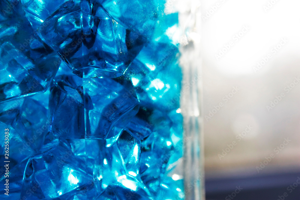 Blue crystals of glass with highlights of light on them, blur, close-up, abstraction.
