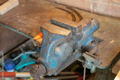 rusty blue bench vice in a rural workshop