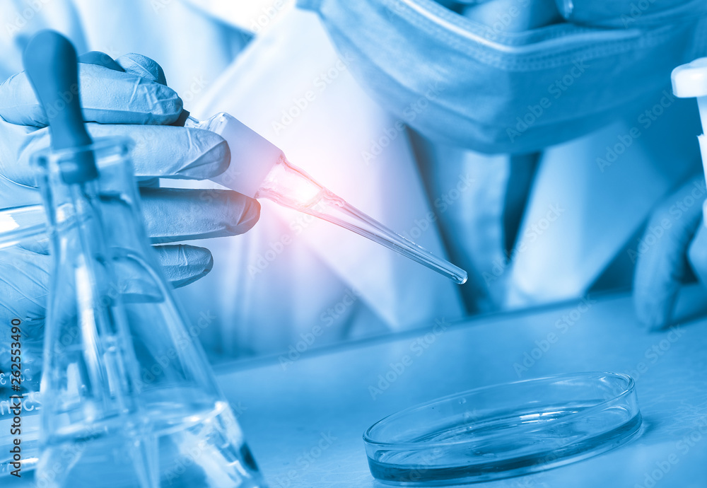 Laboratory beaker in analyst's hand in plastic glove Laboratory beaker in analyst's hand in plastic glove