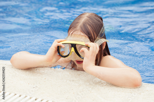 Girl trying on a mask. In the swimming pool