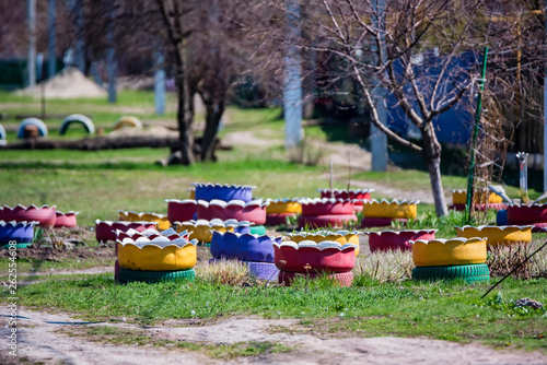 Colorful flowerbeds made of several old car tires