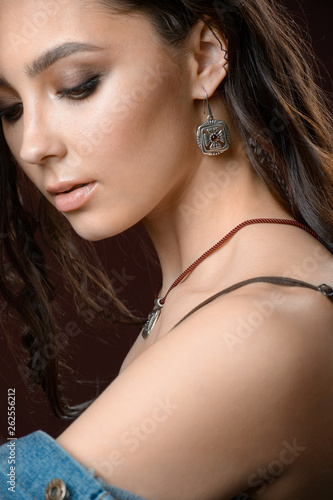 Beautiful woman isolated on brown background. Fashion Model jewelry