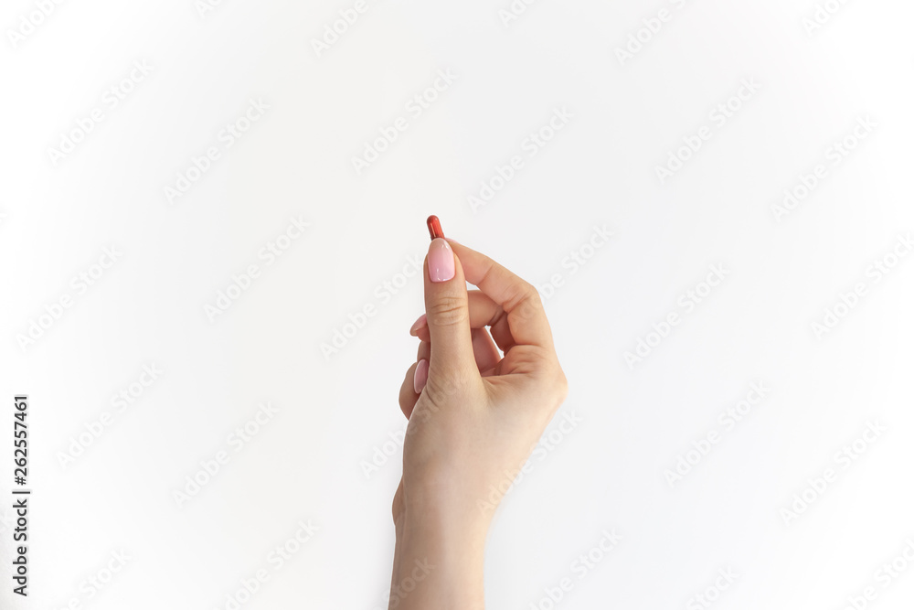 red pill in hand, brown capsule in female fingers on white background red pill in hand, brown capsule in female fingers on white background