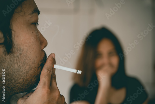 Passive smoking concept.Asian Man is smoking cigarette and woman is covering her face,No tobacco day,Smoking is objectionable to society,Thailand people photo