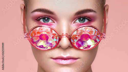 Portrait of Beautiful young Woman with Colored Glasses. Beauty Fashion. Perfect Make-up. Colorful Decoration. Holographic sunglasses. Coral color
