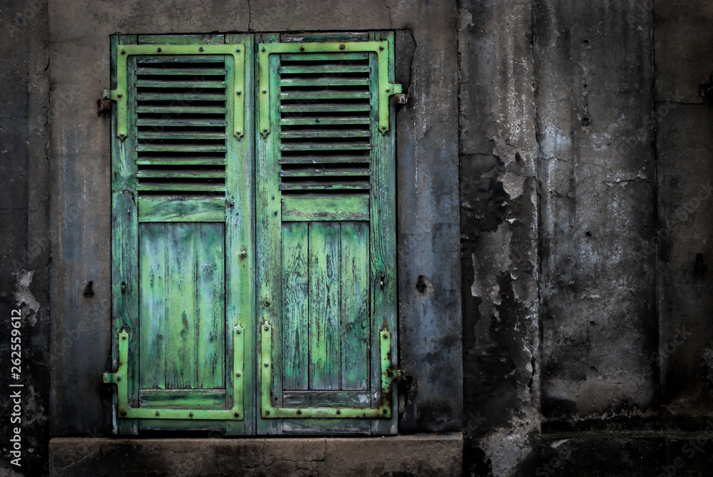 Green shutters on dirty wall