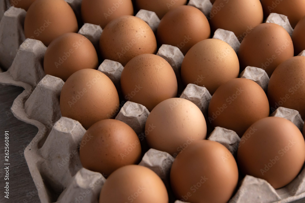 a lot of fresh red eggs in a protective cardboard tray, short focus