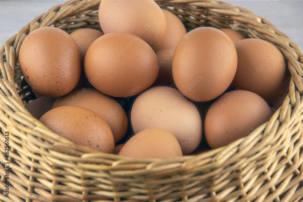 wicker basket with dietary brown eggs, top view, on a wooden table wicker basket with dietary brown eggs, top view, on a wooden table