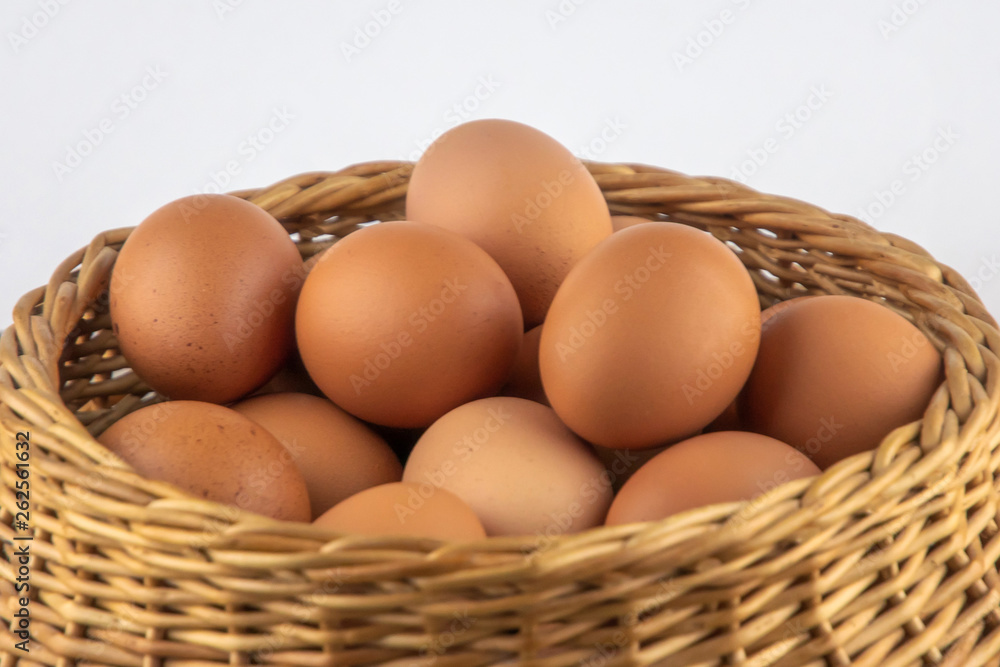 wicker basket with dietary brown eggs, front view, on a wooden table wicker basket with dietary brown eggs, front view, on a wooden table