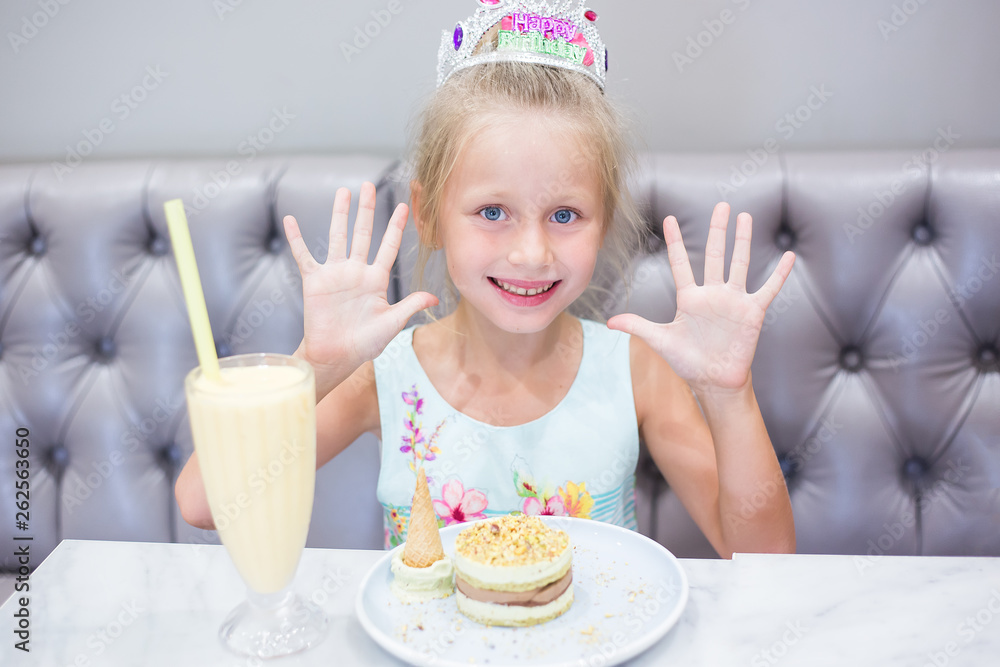 The girl at a birthday party. Joyful cheerful girl celebrates. Cocktail and cake on the table. The girl at a birthday party. Joyful cheerful girl celebrates. Cocktail and cake on the table.