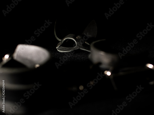 leather handcuffs and a bunny mask on a black background. fetish toys