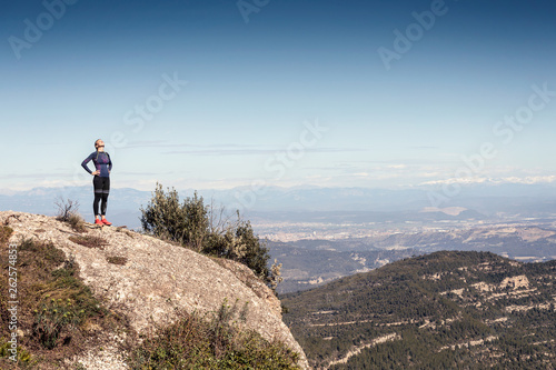 Photography Trail runner standing and taking a break while looking landscape from mountain peak