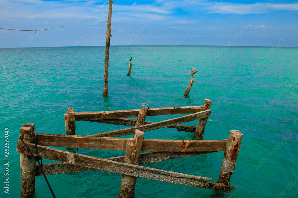 Pier detail on blue caribbean beach with beautiful sky Pier detail on blue caribbean beach with beautiful sky