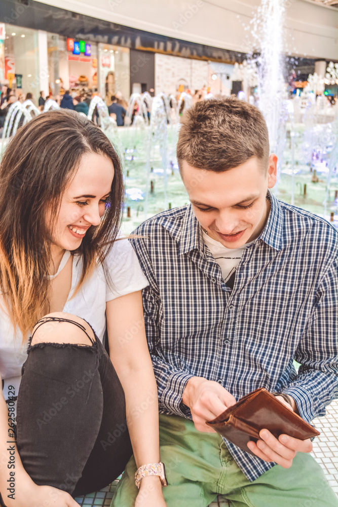 The young married couple on shopping counts money in a purse. Lovers. Finance. The young married couple on shopping counts money in a purse. Lovers. Finance.