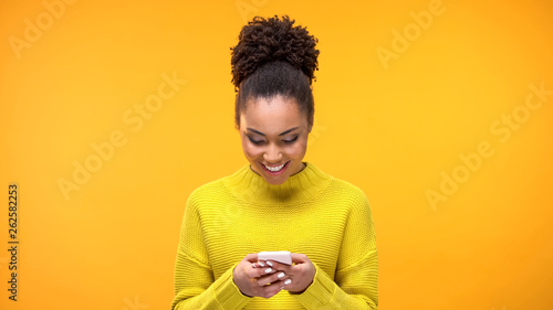 Smiling African-American woman chatting on smartphone, modern technology, app photo