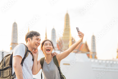 Photography Asian blogger couple travel in Bangkok, Thailand, sweet couple using mobile phone selfie and photo view while spending sweet time in holiday trip in sunset