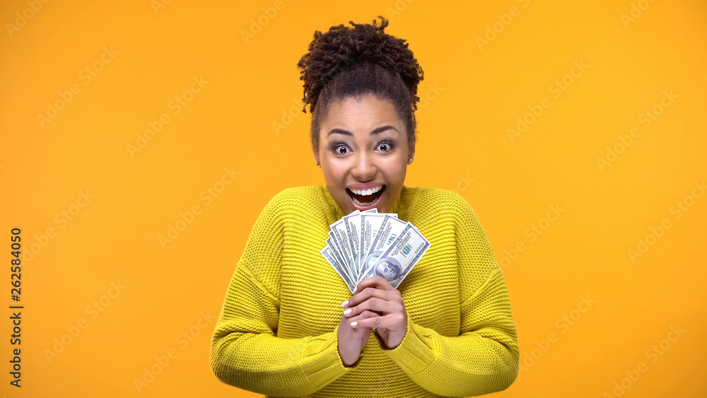 © motortion - Excited Afro-American woman holding bunch of dollars, lottery winner, fortune © motortion - Excited Afro-American woman holding bunch of dollars, lottery winner, fortune