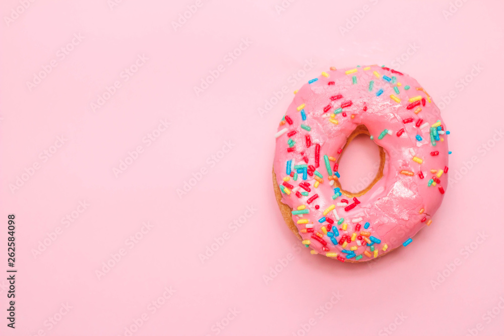 Donut in a pink glaze on a gently pink background. Donut in a pink glaze on a gently pink background.