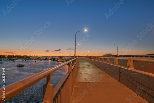 Tauranga Harbour Bridge transport route with road and pedestrian and cycle path with glow of cyclists and vehicle passing lights © Brian Scantlebury