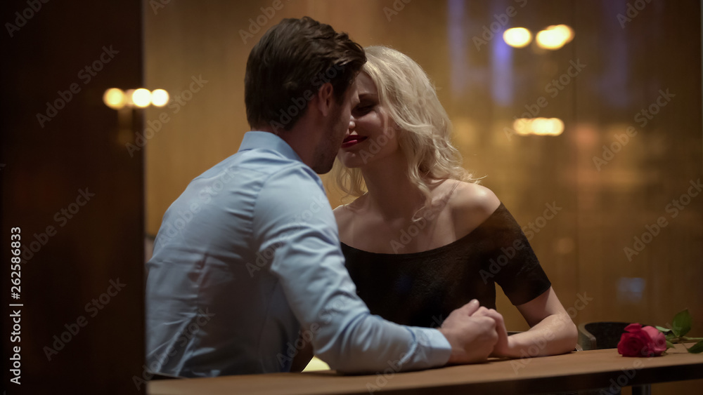 Loving couple kissing in restaurant, enjoying each other, romantic date, passion Loving couple kissing in restaurant, enjoying each other, romantic date, passion
