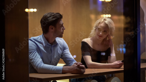 Canvas Print Pretty female flirting with young man at cafe, evening time, pick-up and date