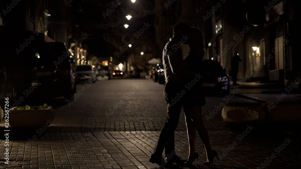 Two loving people kissing tenderly in night street, love in big city, dating