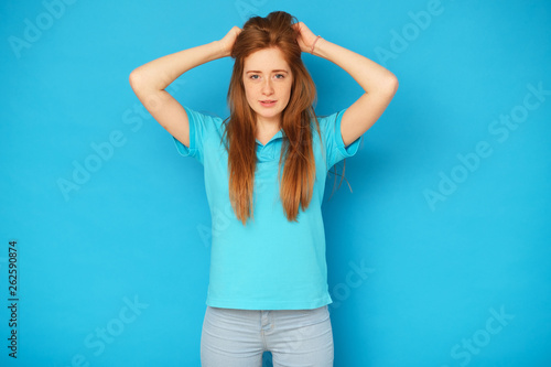 Happy and cute girl standing on blue background.