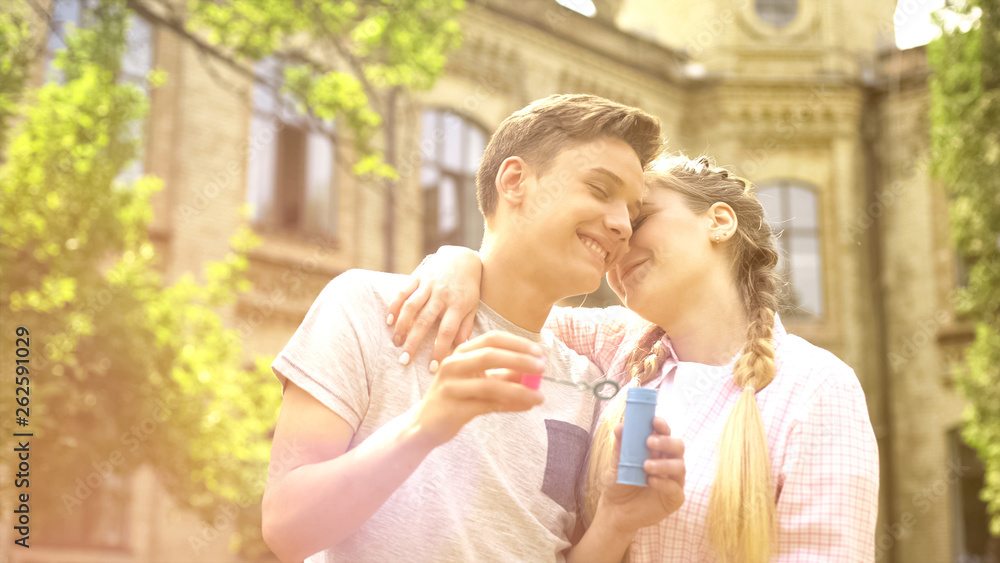 Fototapeta premium Sweet teenagers couple embracing, romantic date outdoors, having fun together
