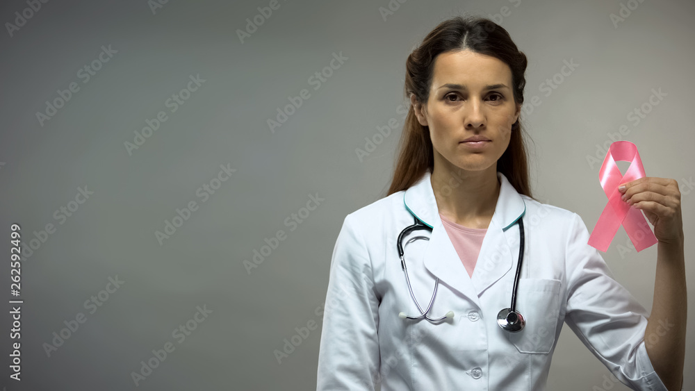 Woman therapist with stethoscope showing pink ribbon, breast cancer awareness Woman therapist with stethoscope showing pink ribbon, breast cancer awareness