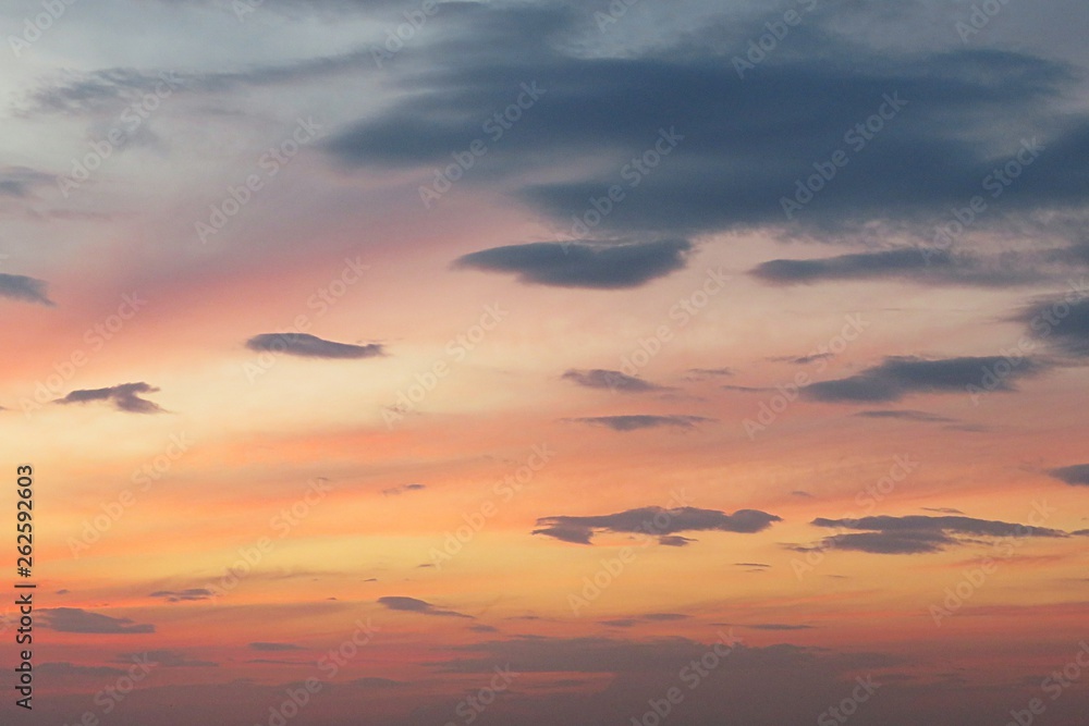 Beautiful bright orange sunset with dark clouds, natural background 