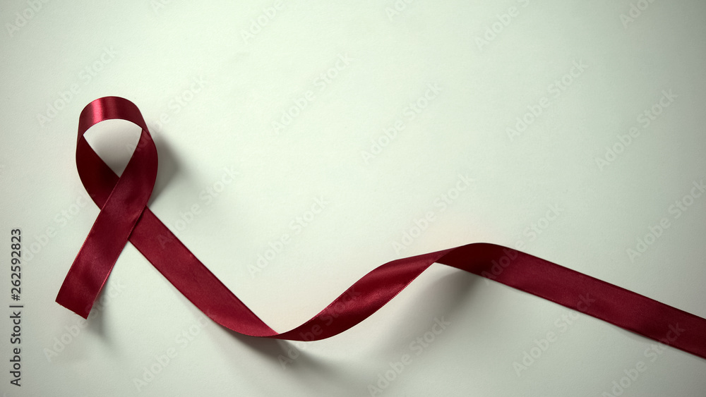 Burgundy ribbon in lady hands, multiple myeloma syndrome awareness,  healthcare Stock Photo