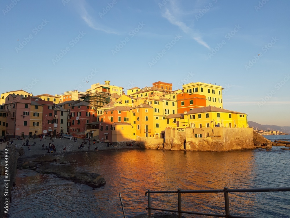 Genova, Italy - 04/15/2019: Boccadasse, a small sea district of Genoa, during the golden hour with some people enjoy the evening