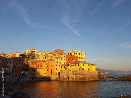 Genova, Italy - 04/15/2019: Boccadasse, a small sea district of Genoa, during the golden hour with some people enjoy the evening